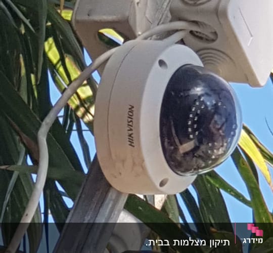 מצלמת אבטחה מותקנת על עמוד עם כבלים